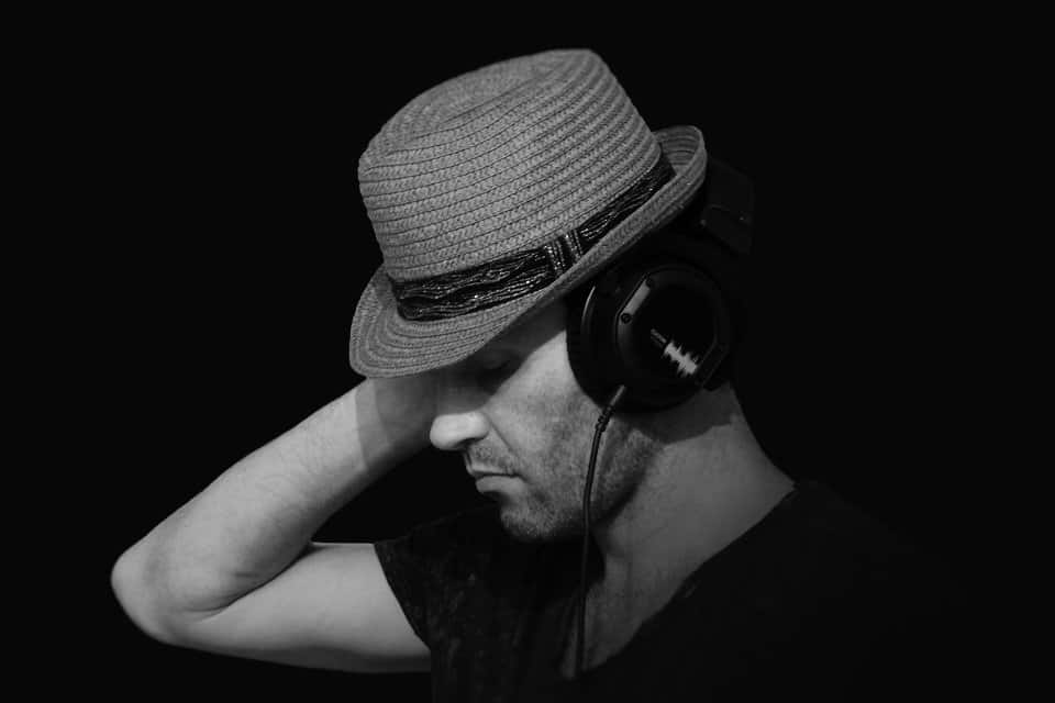 Mann mit Hut und hochwertigem Kopfhörer der eingehend Musik hört